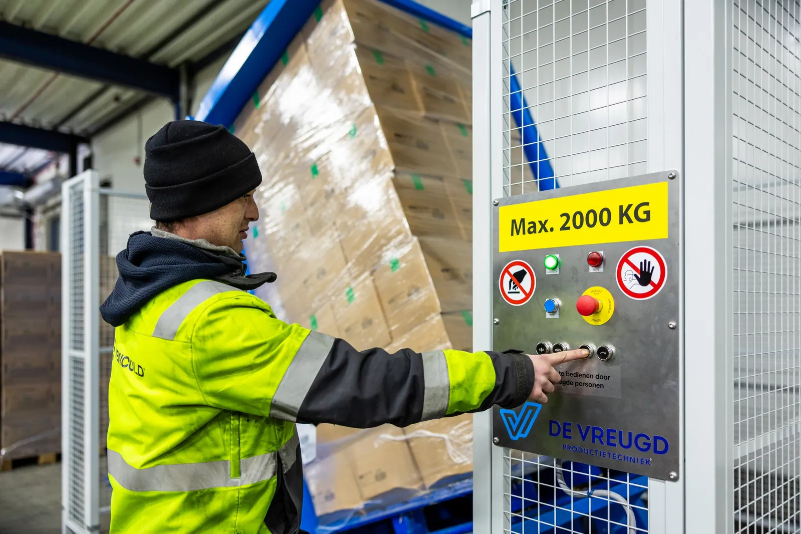 Employee operates the pallet inverter PalletRotator K11 while the pallet tilts