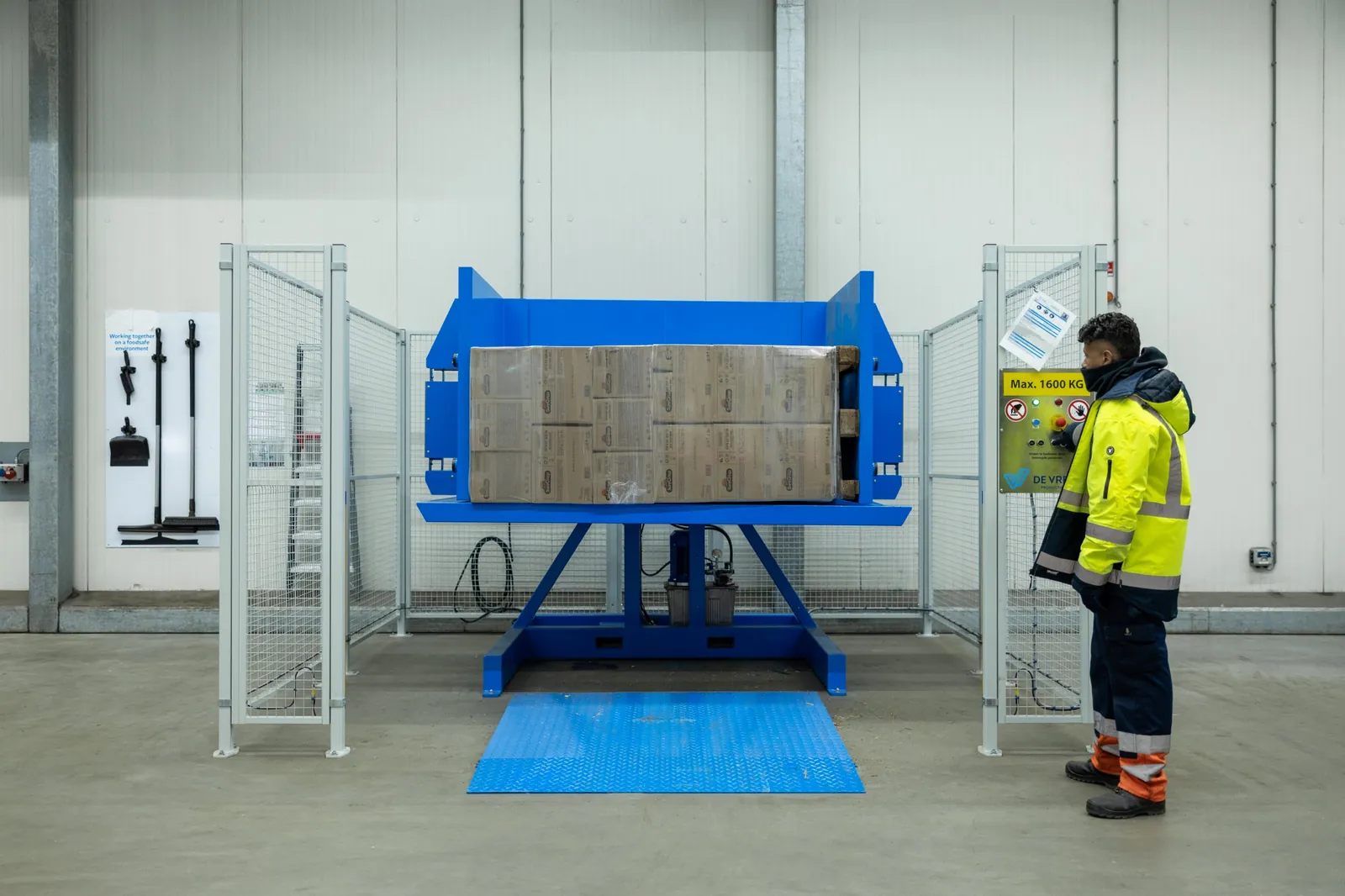 Pallet inverter PalletRotator EPT with tilted pallet and operator at the control panel